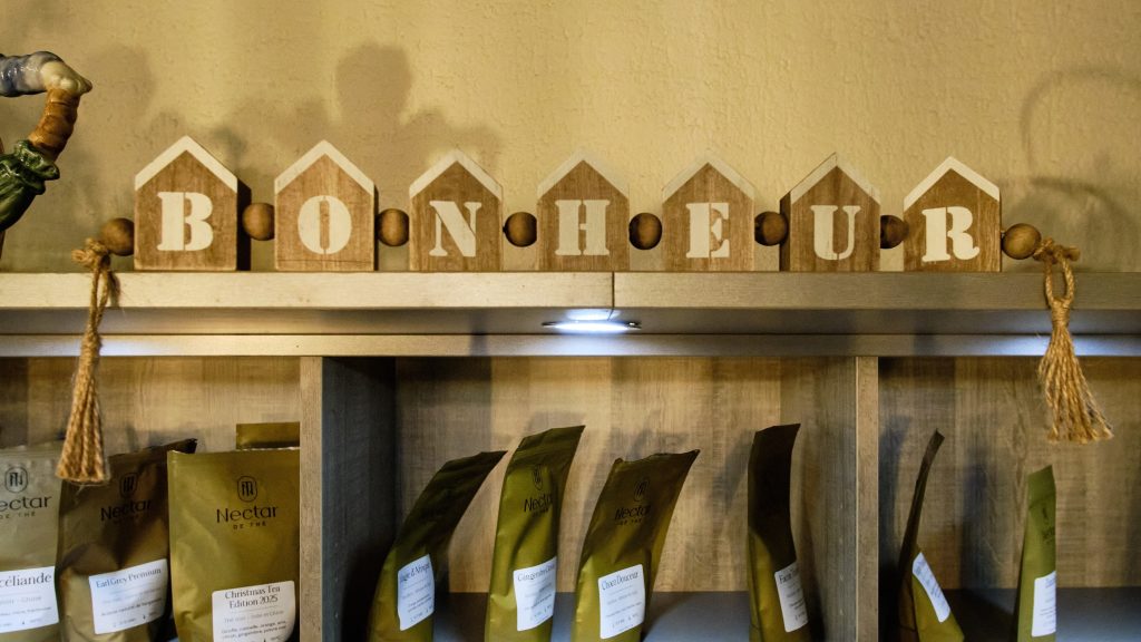Lettres en bois Bonheur au-dessus des étagères de thé à L'Atelier des Anges